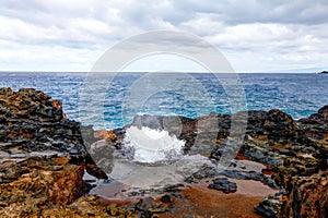 Blow hole with water spraying out. Maui, Hawaii, USA