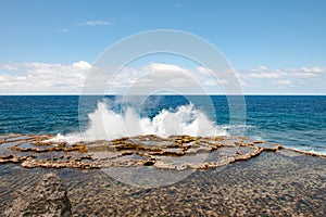 Blow Holes in Tonga, water splashing out rocks on shore of South Pacific Ocean photo