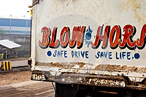 Blow Horn Safe Drive Save Life written on back of a car