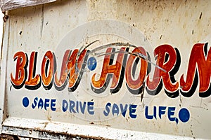Blow Horn Safe Drive Save Life written on back of a car
