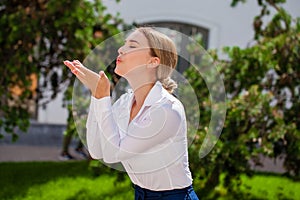 Blow kiss, young caucasian female haired model photo