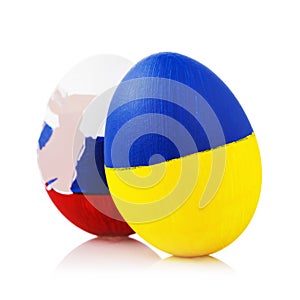 Blow to Orthodoxy: two Easter eggs painted in color of the flags of Russia and Ukraine isolated on white background