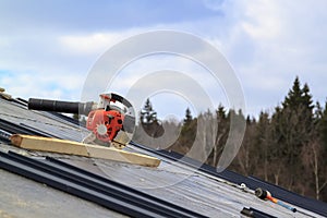 blower on  waterproofing tarpaper layer on folded roof under construction