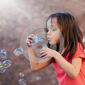 Blowing, bubbles and girl outdoor relax in summer with magic, toys or fun on vacation or holiday. Childhood, memory and