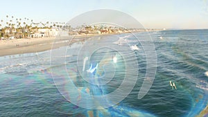 Blowing soap bubbles on ocean pier in California, blurred summertime background. Creative romantic metaphor, concept of dreaming