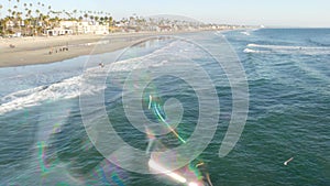 Blowing soap bubbles on ocean pier in California, blurred summertime background. Creative romantic metaphor, concept of dreaming