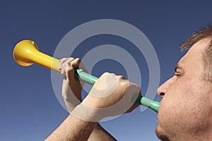 Blowing a vuvuzela