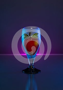 Blown Class Cup with an hand painted apple on dark background and light.