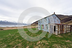 Blue abandoned farmhouse in icelandic fjord. Near Djupivogur inext to the ring road during road trip. photo