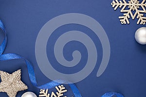 Blue abstract Christmas minimalistic styled background with silver snowflakes, baubles and blue ribbon. Blue mock up with space