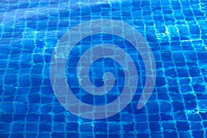 Blue abstract mosaic tiles at the bottom of the swimming pool, background
