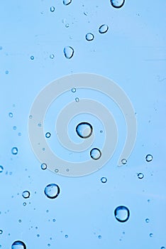 Blue abstract waterdrops on plastic bottle close up vertical macro shot