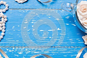 Blue aged wooden table with glass cup full of roses