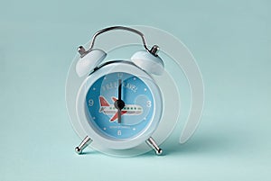 Blue alarm clock on a blue background.