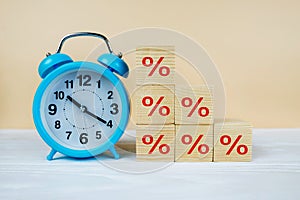 Blue alarm clock and percentages on cubes. Interest rate. inflation, risk management