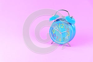 Blue Alarm clock on pink pastel background or isolated