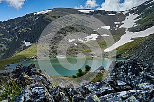 blue alpine lake formed from a glacier on top of a mountain