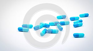 Blue antibiotic capsule pills spread on white background. Antibiotic drug resistance. Pharmaceutical industry. Healthcare and