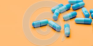 Blue antibiotic capsule pills spread on yellow background. Antibiotic drug resistance. Pharmaceutical industry. Healthcare and
