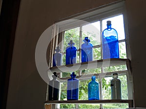 Blue Antique Apothecary vials on a window shelf
