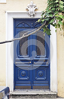 Blue antique entrance door with brass decor and glass wrought-iron windows in Renaissance style