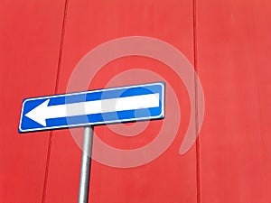 Blue arrow sign on red