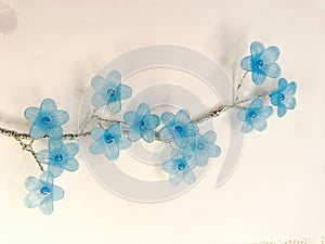 blue artificial flower on the white lace background