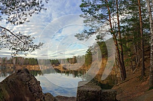 Blue autumn sky with clouds reflected in the pond