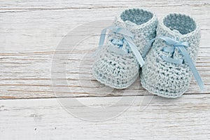 Blue baby booties on weathered wood