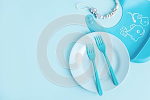 Blue baby plate with cutlery on table