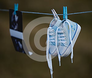 Blue baby shoes hanged on a small rope