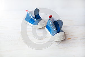 Blue baby sneakers on a wood floor