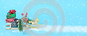 Blue background baner with sled and horse with Christmas and New Year gifts with snow with copy space