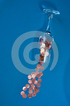 Blue background and champagne glass with sprinkled large pink confetti. Festive mood