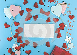 On a blue background  a gift box and a red bow  colored hearts tied together  candy. In the center