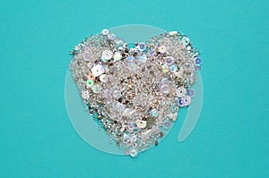 Blue background with heart of sequins and beads