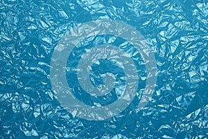 Blue background made of crumpled polyethylene. Abstract blue texture of crumpled plastic film