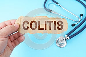 On a blue background, a man holds a cardboard box with the inscription - COLITIS