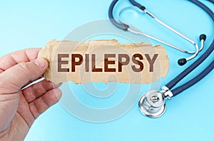 On a blue background, a man holds a cardboard box with the inscription - EPILEPSY
