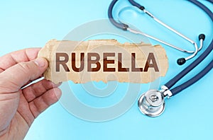 On a blue background, a man holds a cardboard box with the inscription - RUBELLA
