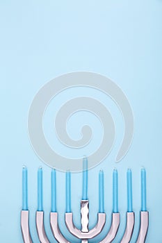 Blue background with menora and candles. Hanukkah and judaic holiday concept.