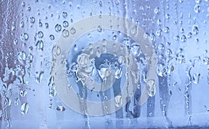 Blue background of natural water condensation, window glass with high air strong humidity, large drops drip. Collecting and