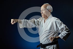 On a blue background, an old man athlete beats a punch arm