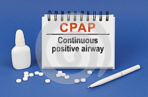 On a blue background, a pen, tablets and a notepad with the inscription - CPAP Continuous positive airway pressure