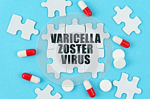 On a blue background, pills, capsules and puzzles with the inscription - Varicella zoster virus