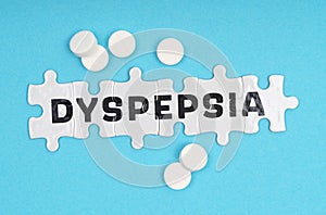 On a blue background pills and puzzles with the inscription - DYSPEPSIA