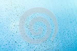 Blue background of rain drops on a window