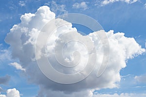 blue background of the summer sky with clouds. A heart-shaped cloud