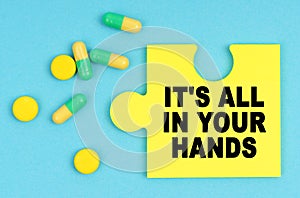 On a blue background, there are pills and a puzzle with the inscription - IT S ALL IN YOUR HANDS