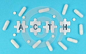 On a blue background, there are pills and puzzles with the inscription - ACTH